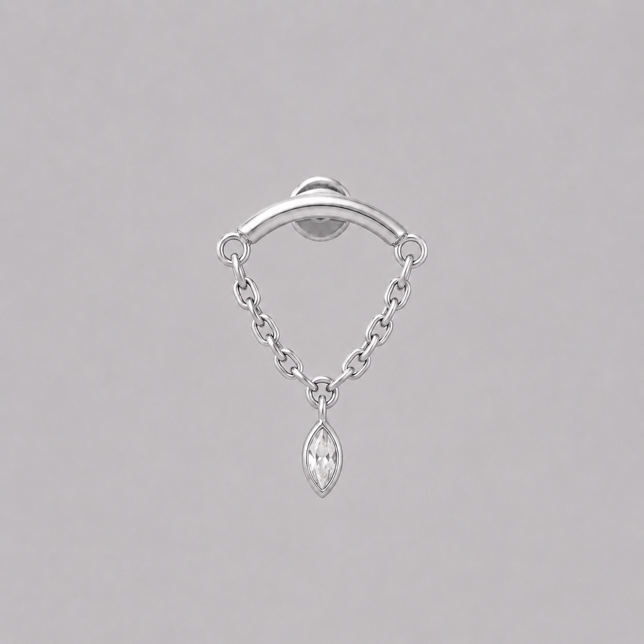 A silver earring featuring a curved bar at the top, a delicate chain drape, and a marquise-cut clear gemstone pendant, shown against a solid gray background.