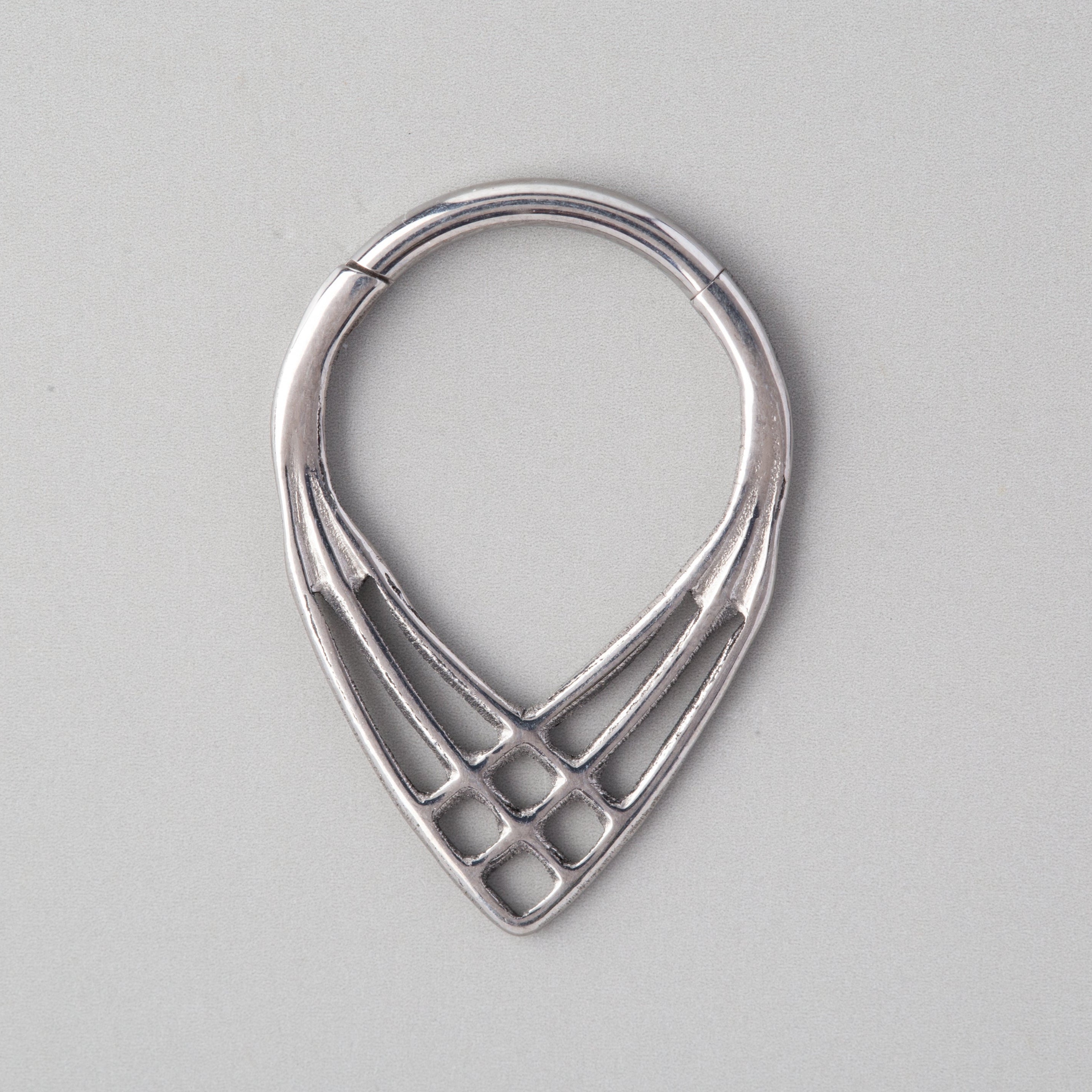 Silver earring on a gray background